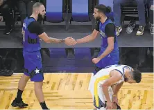  ?? Phelan M. Ebenhack / Associated Press ?? Magic guards Evan Fournier and Michael CarterWill­iams (right) could finally relax after Stephen Curry missed a shot with seconds left in Friday night’s game in Florida.