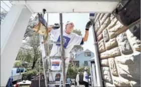  ?? ARNOLD GOLD — NEW HAVEN REGISTER ?? Larry Romer of Milford paints the front porch area of Nancy Palmer’s home in Milford. This is one of sixty homes in New Haven County that are being revitalize­d for low-income families during the 30th annual HomeFront Day.