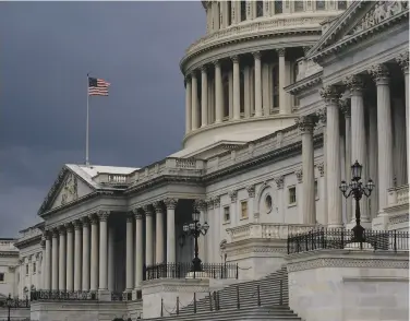  ?? J. Scott Applewhite / Associated Press 2020 ?? Dark clouds hang over the U.S. Capitol on a rainy August day in Washington. The U.S. government’s budget deficit for the first six months of this budget year was nearly double the previous record.