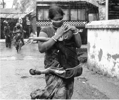  ?? POTO: REUTERS ?? A woman tries to protect her son from heavy rain as they rush to a safer place following their evacuation from a slum area in Kolkata