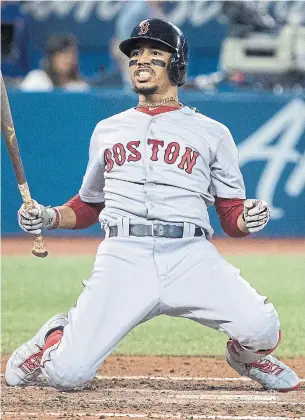  ?? FRED THORNHILL THE CANADIAN PRESS ?? Boston’s Mookie Betts drops to his knees after being backed off the plate by an inside pitch in Tuesday’s game against Toronto. Betts homered on the first pitch of the game.