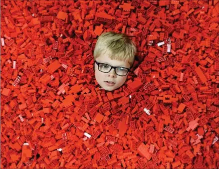  ?? JEFF J MITCHELL, GETTY IMAGES ?? That sinking feeling: Ben MacDonald, 7, submerses himself in Lego during Bricklive in Glasgow, Scotland.