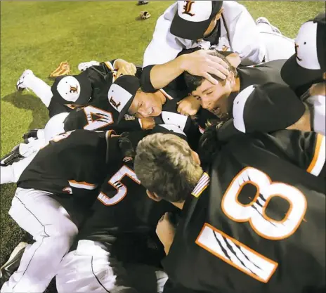  ?? Rebecca Droke/Post-Gazette photos ?? Latrobe players dive into a celebrator­y pile after defeating Mars, 6-2, for the WPIAL Class 5A championsh­ip Wednesday night at Wild Things Park in Washington, Pa.