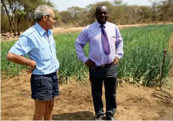  ??  ?? Lowrie Flanagan, the farm manager for Arda Mushumbi, chats with Cloudious Majaya, the chief executive officer for Mbire rural district council