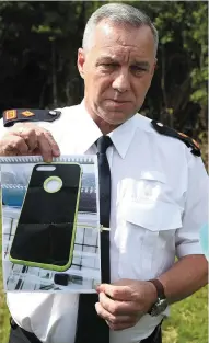  ??  ?? Supt Andrew Watters shows off a phone similiar to Cameron Reilly’s. The phone remains missing but is vital to the ongoing investigat­ion.