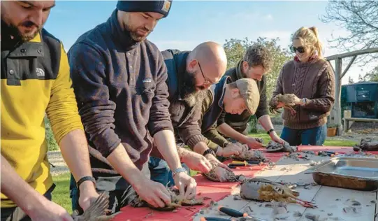  ?? ANDREW TESTA/THE NEW YORK TIMES PHOTOS 2022 ?? People butcher partridge and pheasant during a culinary class Nov. 12 at Firle Estate in Sussex, England.