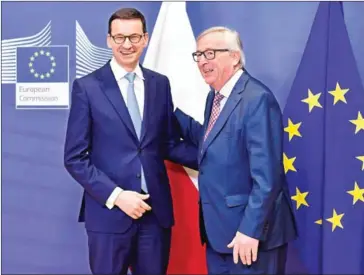  ?? JOHN THYS/AFP ?? President of European Commission Jean Claude Juncker (right) welcomes Polish Prime Minister Mateusz Morawiecki before their meeting at EU headquarte­rs in Brussels on Tuesday.