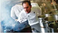  ??  ?? French chef Alexandre Couillon blows on a barbecue using pine cones in the kitchen of his restaurant.