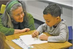  ?? BY HOLLY JENKINS ?? RCPS School Board Member Rachel Bynum assists Franklin Johnson in observing classroom sprouts