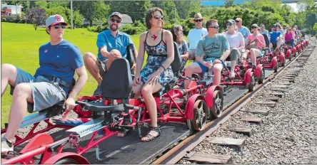  ?? JENNIFER MCDERMOTT/AP PHOTO ?? A Rail Explorers tour stops to admire the view by the Mount Hope Bridge in Portsmouth, R.I., on July 8. Rail Explorers opened in Portsmouth in April as part of the Newport and Narraganse­tt Bay Railroad.