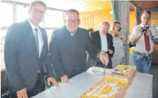 ??  ?? Bürgermeis­ter Lothar Fischer und der Primiziant schneiden die Torte an.
