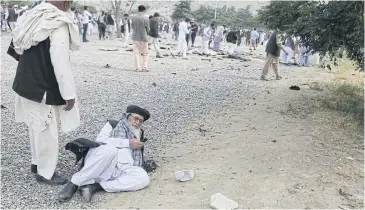  ?? EPA ?? An elderly man injured in the Kabul funeral blasts on Saturday attempts to make a phone call.
