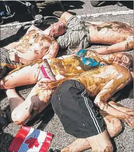  ?? | TINA SFONDELES~SUN-TIMES ?? Protesters lay in the street as others chant “No blood for oil” outside the Canadian consulate in Chicago on Thursday.