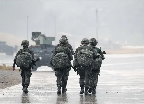  ??  ?? South Korean soldiers walk as rain falls during Warrior Strike VIII, a bilateral training exercise with the U.S. Army. A key South Korean official has confirmed a recent hack by North Korea includes important military informatio­n, including joint...