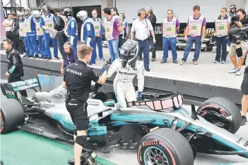  ??  ?? Mercedes’ Finnish driver Valtteri Bottas (right) celebrates with a teammate after taking the pole position for the Brazilian Formula One Grand Prix in the Q3 qualifying session at the Interlagos circuit in Sao Paulo, Brazil. — AFP photo