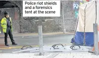  ??  ?? Police riot shields and a forensics tent at the scene