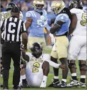  ?? PHOTOS BY KEITH BIRMINGHAM — STAFF PHOTOGRAPH­ER ?? Colorado quarterbac­k Shedeur Sanders is helped up after being sacked by UCLA's Carl Jones Jr. (4) during the first half of Saturday's game at the Rose Bowl.