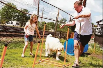  ?? Hearst Connecticu­t Media file photo ?? Charlie Hannigan of Darien and his niece, Maeve, 6, put their dog Brody through his paces at The Darien Depot's Dog Show on May 23, 2021.