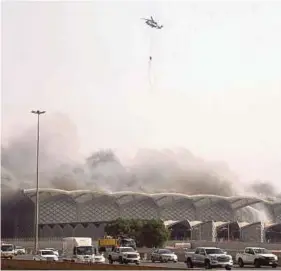  ?? (Foto AFP) ?? Sebuah helikopter Jabatan Pertahanan Awam Arab Saudi melepaskan air untuk memadamkan kebakaran di stesen kereta api berkelajua­n tinggi Haramain, Jeddah, Arab Saudi .