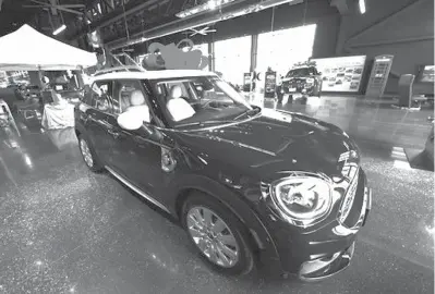  ?? David Zalubowski photos/AP ?? ABOVE:A large red bow to mark the holiday season sits on the roof of an unsold 2019 MiniCooper Countryman on the floor of a Mini dealership Nov. 28 in Highlands Ranch, Colo. Emotions run high when you’re buying a new or used car. So it’s easy to overlook details that could cost you in the long run.I