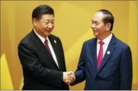  ?? JORGE SILVA — POOL PHOTO VIA AP ?? Vietnam’s President Tran Dai Quang, right, shakes hands with China’s President Xi Jinping at the APEC Economic Leaders’ Meeting in Danang, Saturday. Trade ministers from 11 Pacific Rim countries said they reached an agreement Saturday to proceed with...