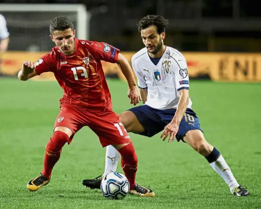  ?? — Reuters ?? Out of my way: Macedonia’s Enis Bardhi (left) in action against Italy’s Marco Parolo during the World Cup qualifier in Turin on Friday. The match ended in a 1-1 draw.