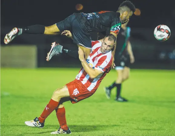  ?? Picture: GLENN CAMPBELL ?? Casuarina’s Gordon Pereira takes the aerial route as he battles for possession with Olympic’s Daniel Roska at the Darwin Football Stadium last night