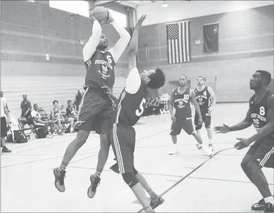  ?? PHOTOS BY SAM MORRIS ?? Jelan Kendrick, left, shoots over Rashad Muhammad during their game on the first night of the Desert Reign tournament last week.