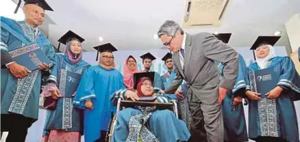  ??  ?? Daing Nasir (tengah) berbual dengan graduan orang kurang upaya, Siti Hawa Apandi sambil diperhatik­an penerima anugerah khas lain.