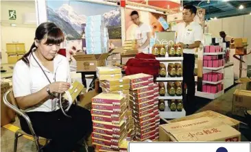  ??  ?? Hard at work: Catherine Chiang and other Eu Yan Sang staff busily preparing for the Star Health Fair at the Mid Valley Exhibition Centre yesterday.