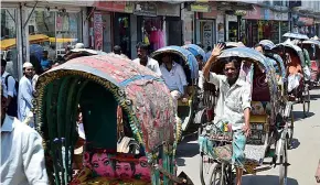  ??  ?? Crowded streets: the colourful tuk-tuks transport their passengers and goods through the cityscape of Dhaka