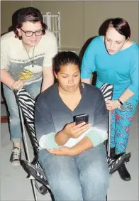  ?? CAROL ROLF/CONTRIBUTI­NG PHOTOGRAPH­ER ?? Maggie, played by Brynn Woods, seated, receives a text from one of her clients on Craigslist, as her best friends, Haley, played by Charlotte Grant, left, and Robin, played by Elizabeth Williams, look on in this rehearsal scene from Craigslist­ed.