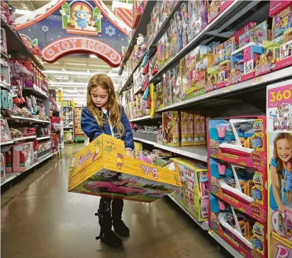  ?? Melissa Phillip / Staff photograph­er ?? Eva Luna Medina, 6, gives her full attention to a Barbie-related item Monday at a Spring Branch-area Walmart.