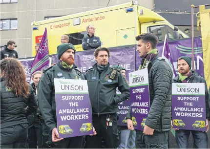  ?? BLOOMBERG ?? Ambulance service workers hold placards outside the London Ambulance Service headquarte­rs in London.