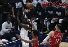  ?? GERALD HERBERT — THE ASSOCIATED PRESS ?? Lakers guard Patrick Beverley (21) goes to the basket over New Orleans Pelicans guard Trey Murphy III and center Jonas Valanciuna­s in the first half in New Orleans on Feb. 4.