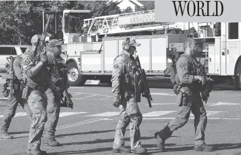  ?? SAUL LOEB / AFP / GETTY IMAGES ?? A police SWAT team moves into position after a shooting Thursday in Annapolis, Md. At least five people were killed when a gunman opened fire inside the offices of the Capital Gazette newspaper. Annapolis is about an hour east of Washington.