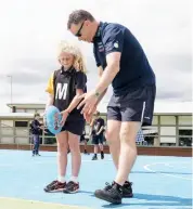  ??  ?? AFL Gippsland’s Paul Vaughan give some guidance to Warragul North primary school’s Emma Henshall on how to prepare to kick a football.