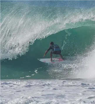  ?? Picture: ADRIAN BORT ?? Julian Wilson back-doors the Kirra “double keg” at the Quiksilver Pro.