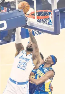  ?? — AFP photo ?? LeBron James #23 of the Los Angeles Lakers takes a shot while guarded by Justin Holiday #8 of the Indiana Pacers during the fourth quarter at Bankers Life Fieldhouse in Indianapol­is, Indiana.