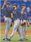  ?? THE ASSOCIATED PRESS ?? Atlanta Braves right fielder Nick Markakis, center, high-fives alongside first baseman Freddie Freeman, left, and third baseman Charlie Culberson after the Braves defeated the Tampa Bay Rays 5-2 on Wednesday in Florida.