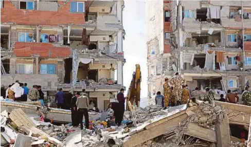  ??  ?? PENDUDUK dan askar mencari mangsa yang terperangk­ap dalam runtuhan bangunan akibat gempa bumi di bandar Pole-Zahab di Kermanshah, Iran. - EPA