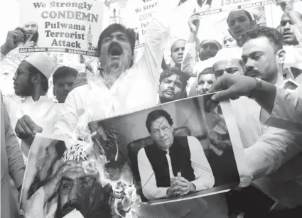  ??  ?? Indian muslims burn posters of Pakistani Prime Minister Imran Khan, center, and Jaish- e-Mohammed leader Masood Azhar, during a protest against Thursday’s attack on a paramilita­ry convoy in Kashmir that killed at least 40 in Mumbai, India. WASHINGTON, D. C.: