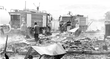  ??  ?? Lebanese firefighte­rs inspect the damage caused by the massive fire. — AFP photo