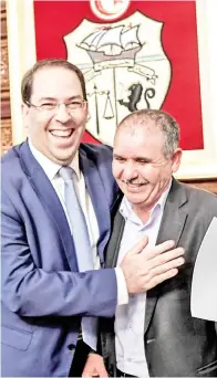  ??  ?? PERDANA Menteri Tunisia Youssef Chahed merangkul Setiausaha Agung UGTT Noureddine Taboubi selepas memeterai perjanjian mengenai tuntutan kenaikan gaji di Tunis, baru-baru ini. — Gambar AFP