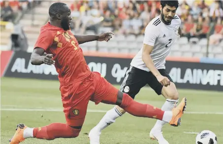  ??  ?? Romelu Lukaku (left) stretches for a toe-poke under pressure from Egypt’s Ali Gabr in last night’s friendly victory.