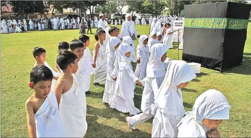  ?? HANUNG HAMBARA/JAWA POS ?? TAK ADA YANG MENANGIS: Anak TK dari Gugus 7 dan 8 Kecamatan Sidoarjo sedang praktik manasik haji bersama di lapangan Desa Sidokare kemarin.