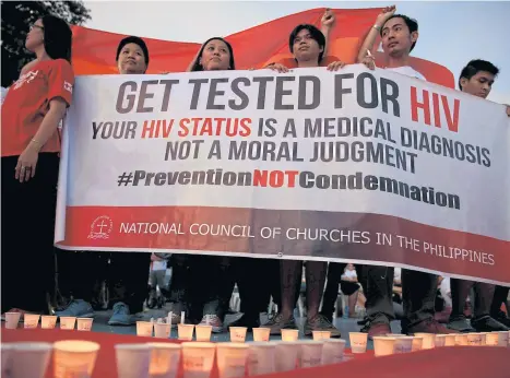  ??  ?? Activists display a banner after lighting 1,638 candles representi­ng the number of HIV/Aids fatalities in the Philippine­s since 1984 at a rally in Quezon City in May this year.