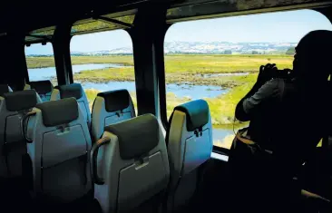  ?? Photos by Michael Macor / The Chronicle ?? Above, a media member photograph­s the route aboard the SMART train as it leaves Petaluma en route to San Rafael. Below, conductor engineer Mike Clift boards in Petaluma for the demonstrat­ion run.