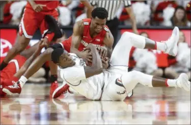  ?? JOHN MINCHILLO — THE ASSOCIATED PRESS ?? Ohio State’s C.J. Jackson, above, battles for a loose ball against Cincinnati’s Trevon Scott, below, during the first half Nov. 7 in Cincinnati.