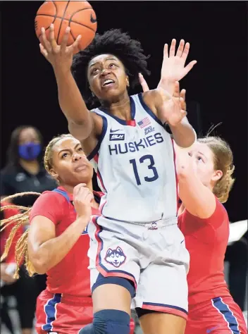  ?? Charles Rex Arbogast / Associated Press ?? UConn’s Christyn Williams (13) scores past DePaul’s Deja Church, left, and Jorie Allen on Sunday. Williams led the Huskies with a career-high 29 points.